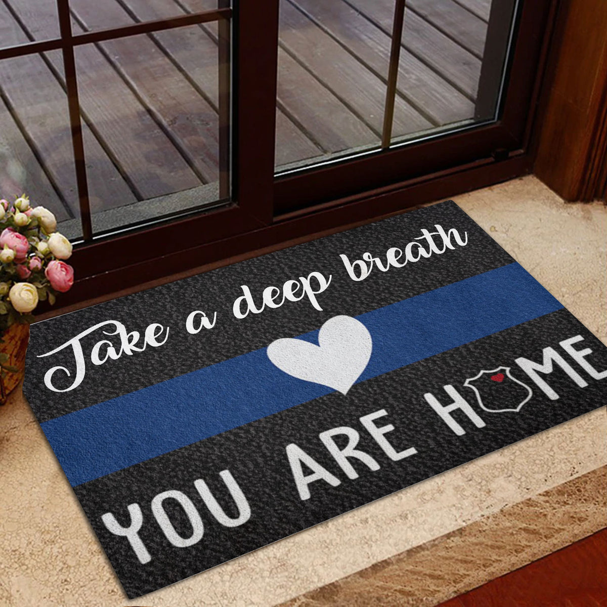 Police blue line entryway mat displayed beside a glass door with a welcoming design