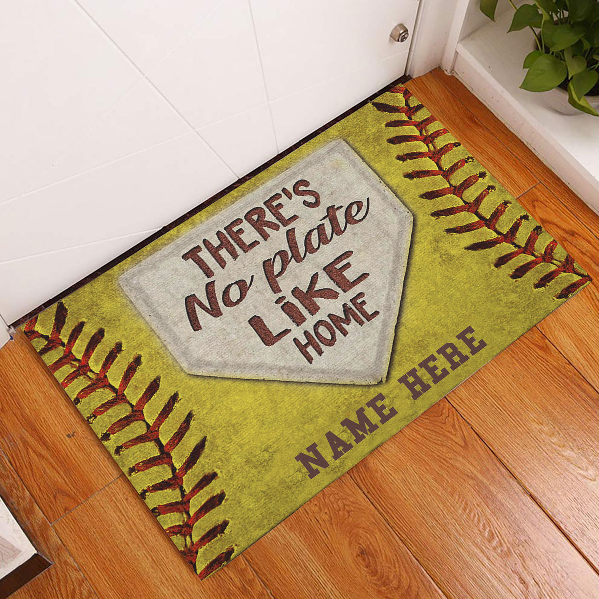Softball-themed doormat displayed by a white door on a wood floor with yellow stitching artwork