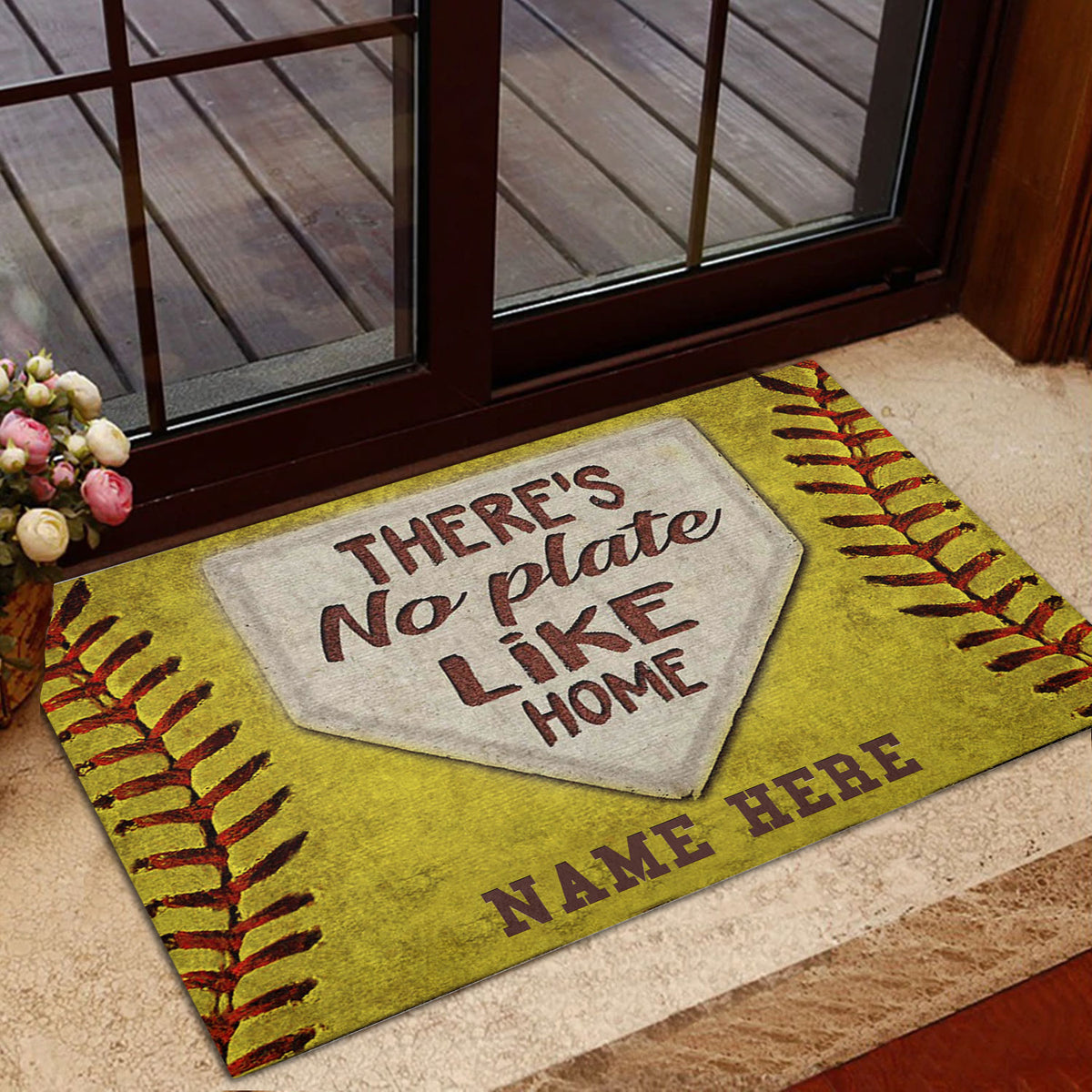 Softball doormat displayed near a glass door with yellow stitching and home plate artwork