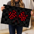 Person holding a black and red racing mat with crossed checkered flags