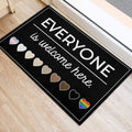 Inclusive LGBT door mat beside an entry door with welcome lettering and colorful pride hearts