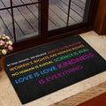 Colorful LGBT doormat styled inside a glass entryway near a deck and floral decor