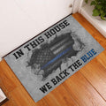 Blue-line police support doormat displayed at a home entryway on hardwood flooring