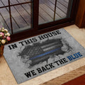 Blue-line police support door mat placed near a glass entry door with floral decor
