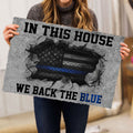 Police-themed doormat held indoors, featuring a blue line emblem and bold patriotic-style design