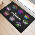 Colorful LGBT paw print door mat arranged around a white welcome message near a doorway