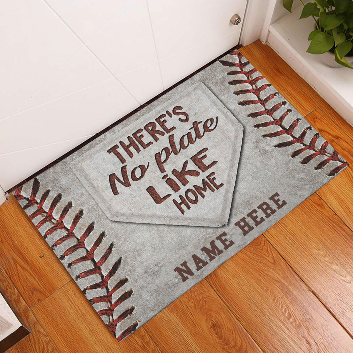 Baseball-themed doormat displayed by a white door on a warm wood floor