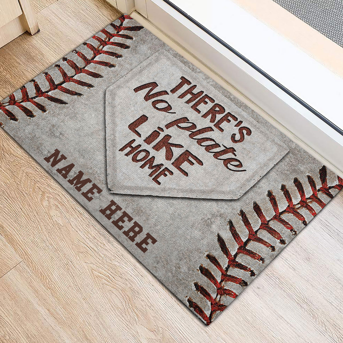 Baseball stitching and home plate design shown on a doormat beside an interior doorway
