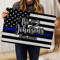 Person holding a police-support doormat featuring stars, stripes and a blue stripe