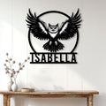 Black owl wall sign displayed on a white paneled wall above a console table