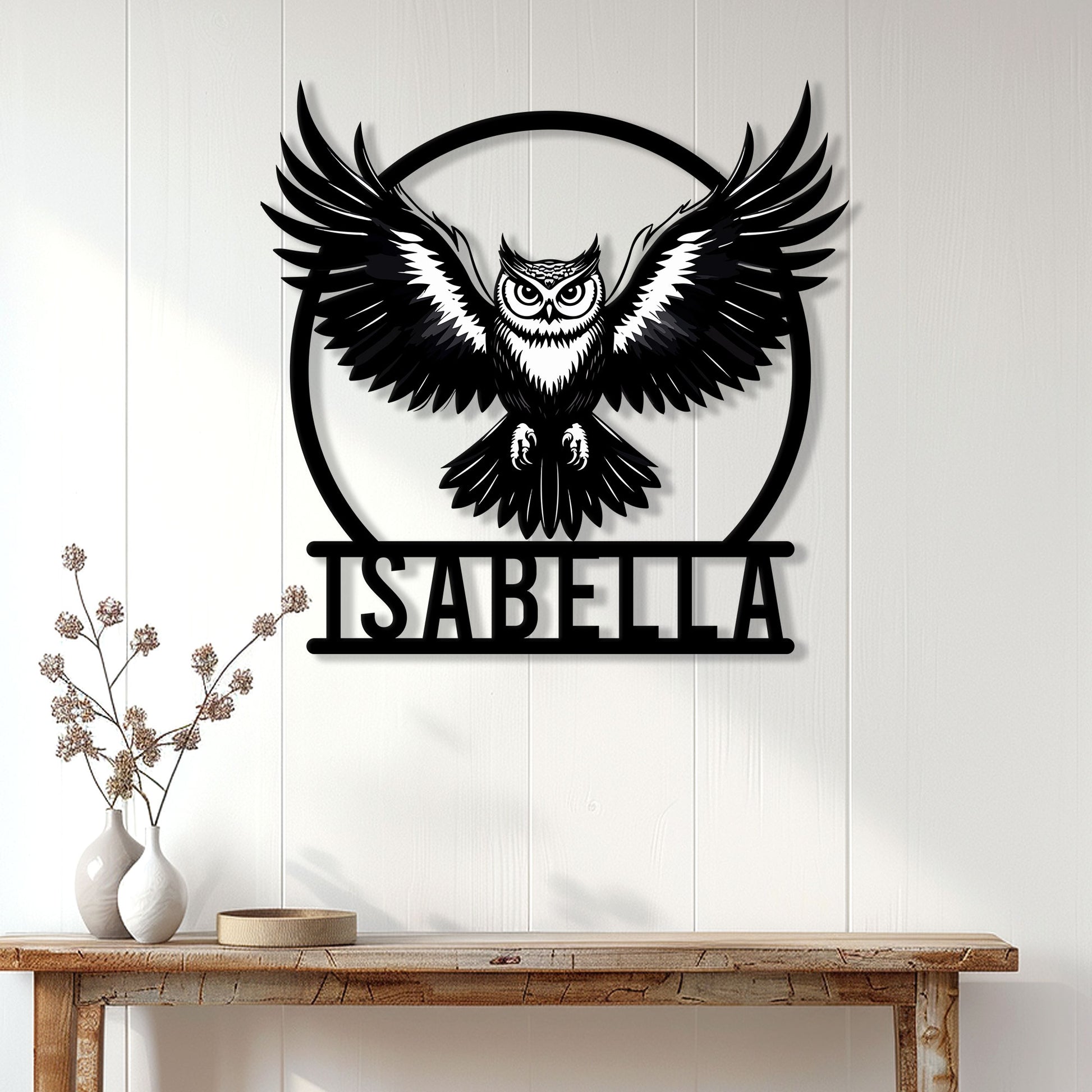 Black owl wall sign displayed on a white paneled wall above a console table