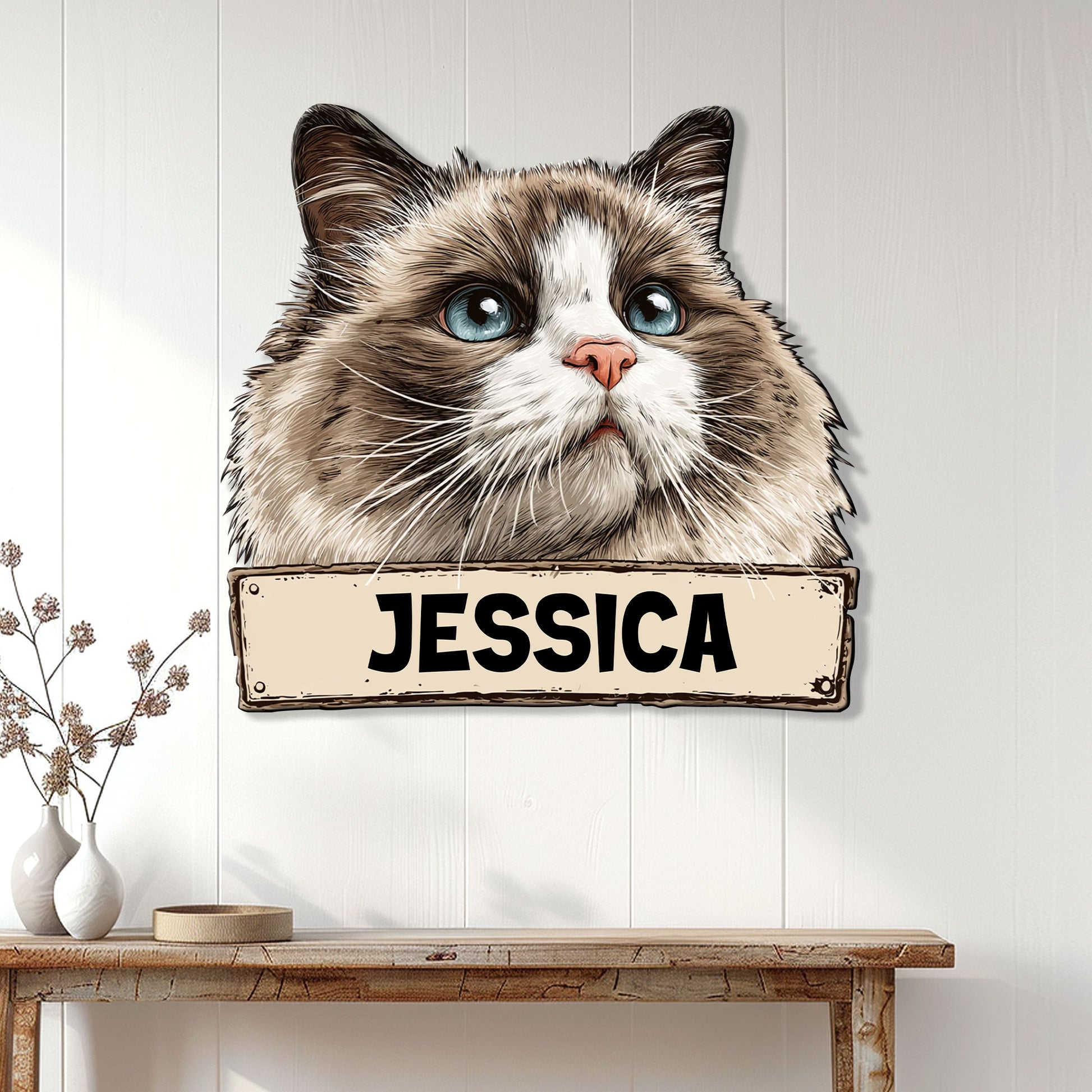Ragdoll cat wall sign displayed on white paneling above a console table in a bright home