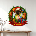 Siamese cat holiday metal sign displayed on a white paneled wall above a console table