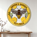 Bee garden metal sign displayed on a white paneled wall above a wooden console table