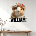 Floral guinea pig wall sign displayed on a light wood-paneled wall above a console table