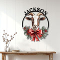 Christmas goat metal sign displayed on a white paneled wall above a rustic console table
