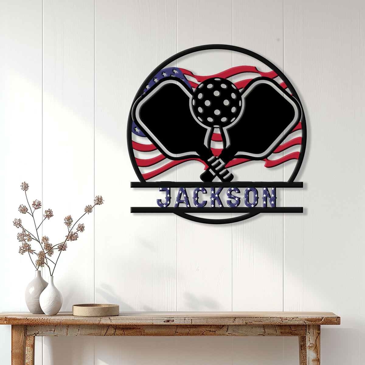 Pickleball wall sign displayed on white paneling with crossed paddles and an American flag-inspired design