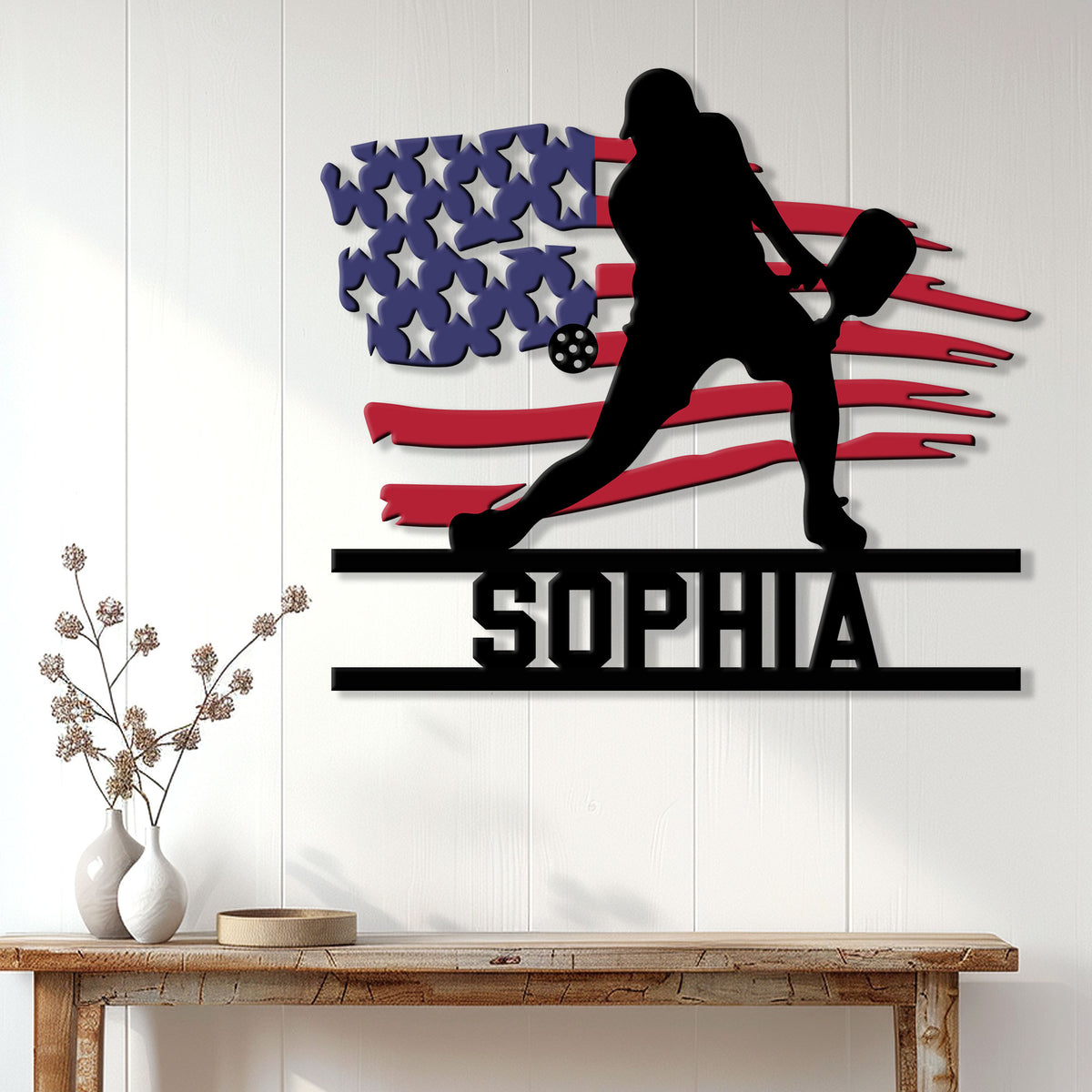 Patriotic pickleball wall sign displayed on a white paneled wall above a console table