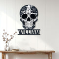 Floral skull metal wall sign displayed on a light paneled wall above a console table