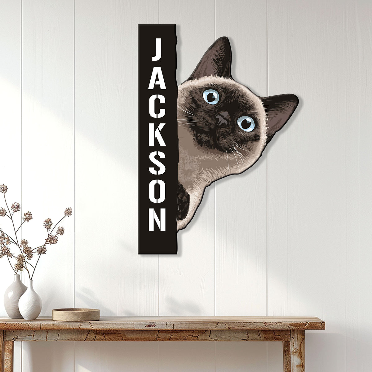 Siamese cat metal wall sign displayed on a white paneled wall above a console table