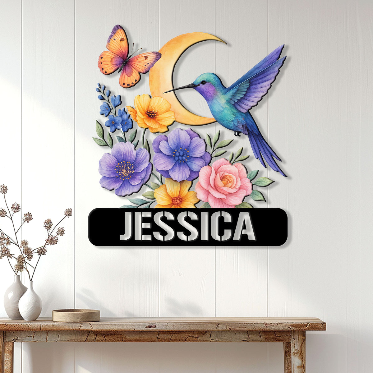 Hummingbird flower wall sign displayed on a white paneled wall above a wooden console table