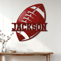 Red football wall sign displayed on a light wood-paneled wall above a console table