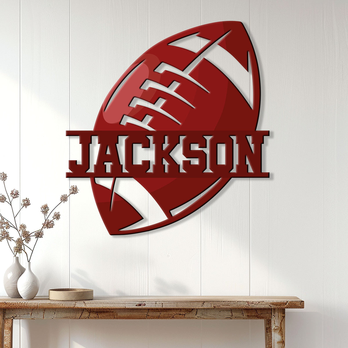 Red football wall sign displayed on a light wood-paneled wall above a console table