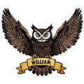 Close-up of a detailed owl metal sign with wide wings, textured feathers, and decorative ribbon