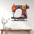 Floral sewing machine wall sign displayed above a console table in a bright home interior