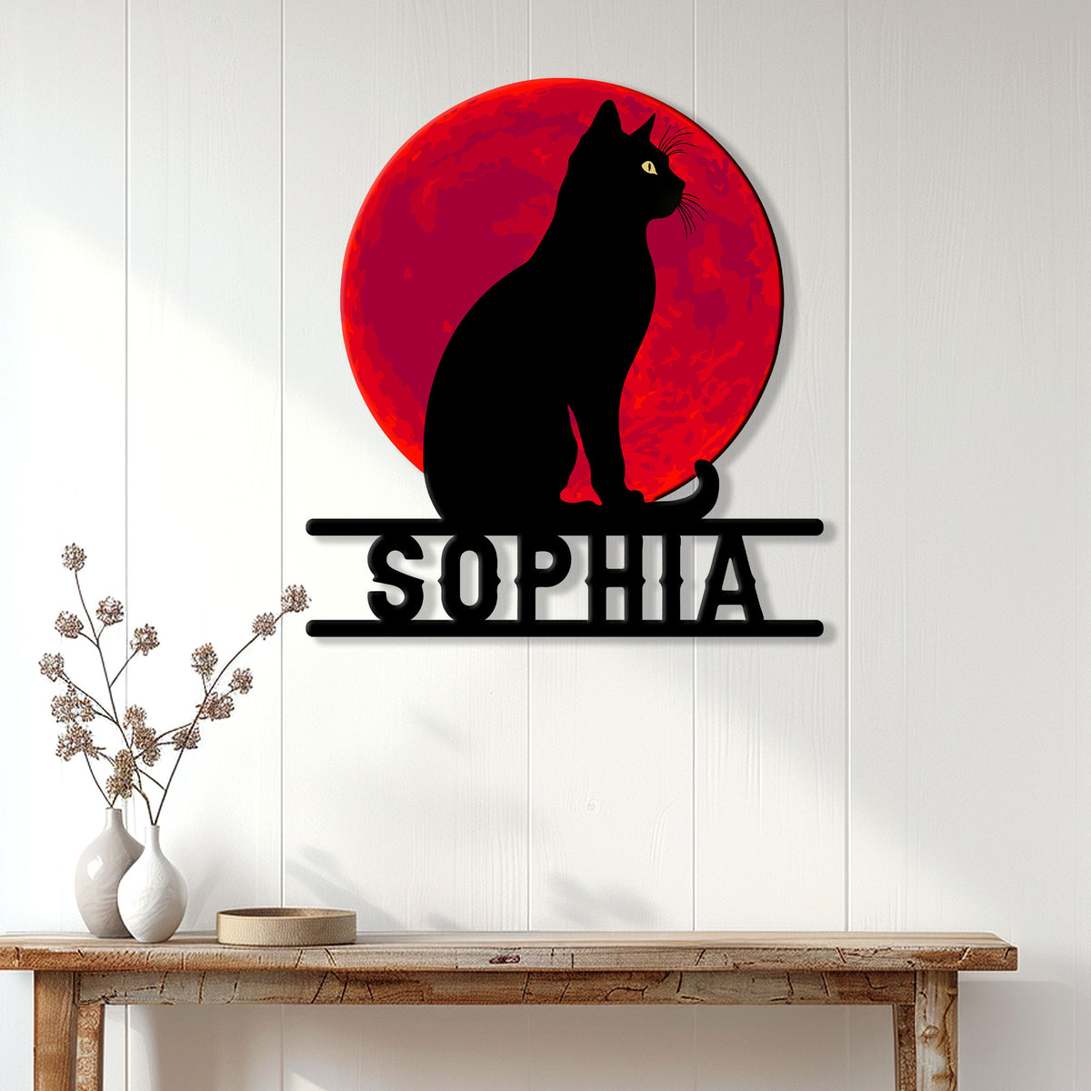 Black cat metal wall sign displayed on a light paneled wall above a wooden console table