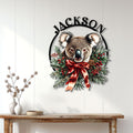 Koala holiday wall decor displayed on a white paneled wall above a wooden console table