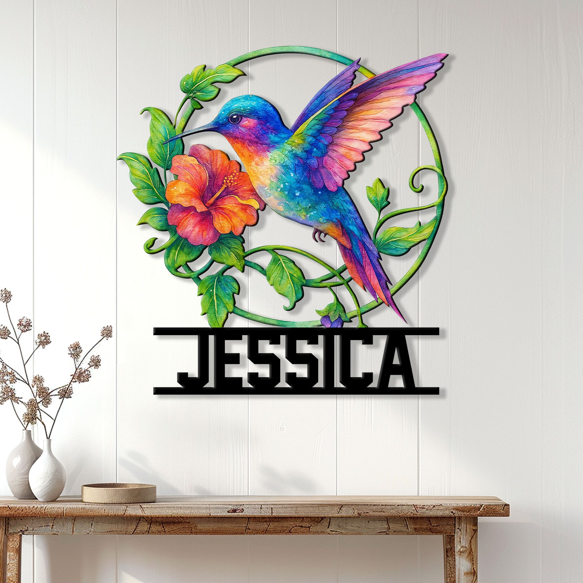 Colorful hummingbird wall sign displayed on a light paneled wall above a wood console table