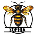 Geometric honey bee metal sign featuring golden wings, a black circular frame, and bold striped detailing