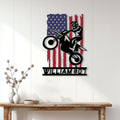 Motocross rider metal wall sign displayed on a bright white paneled wall above a rustic console