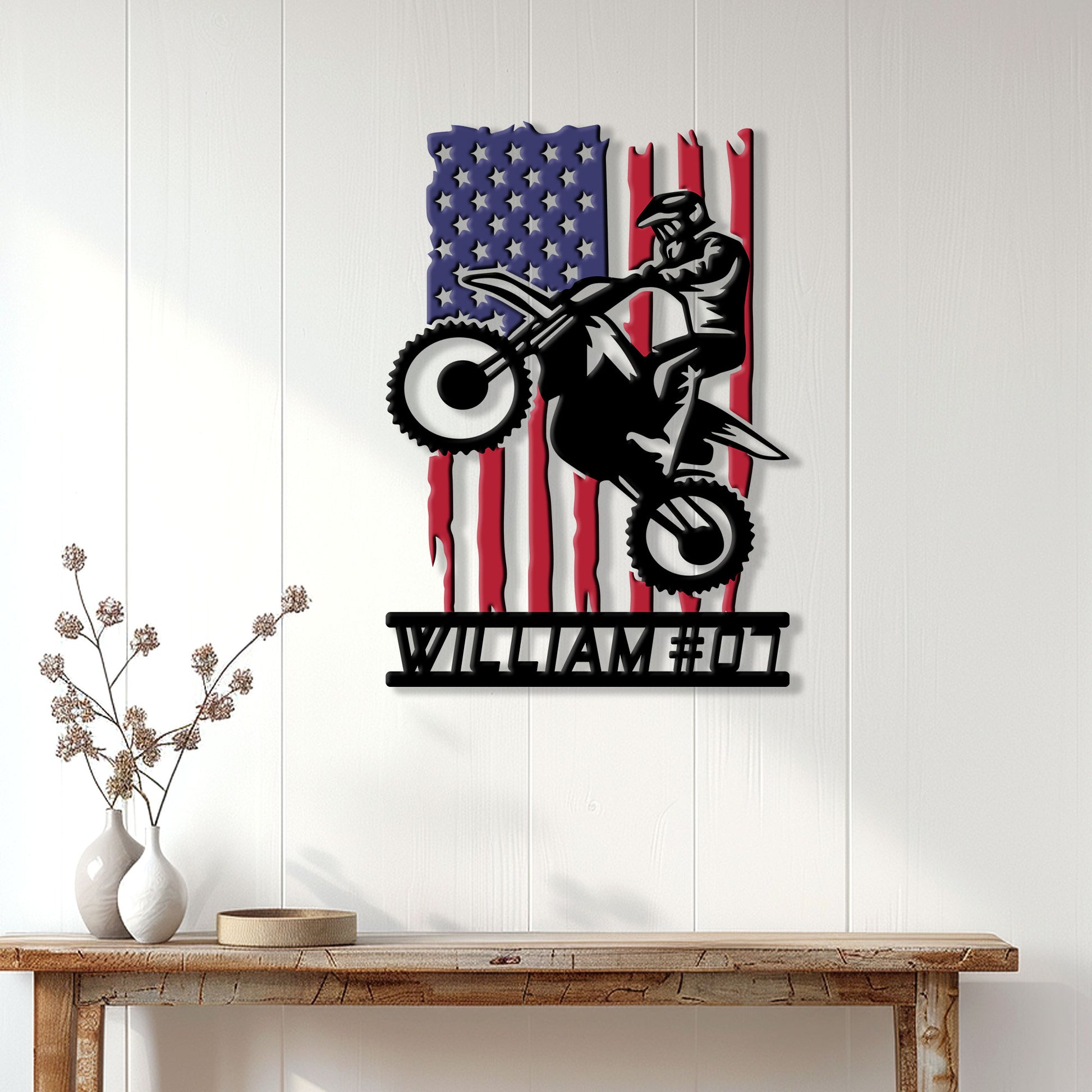 Motocross rider metal wall sign displayed on a bright white paneled wall above a rustic console