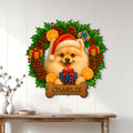 Christmas Pomeranian wall sign displayed on a white paneled wall above a console table