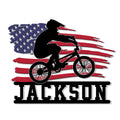 Patriotic BMX metal sign featuring a rider silhouette over a distressed American flag design