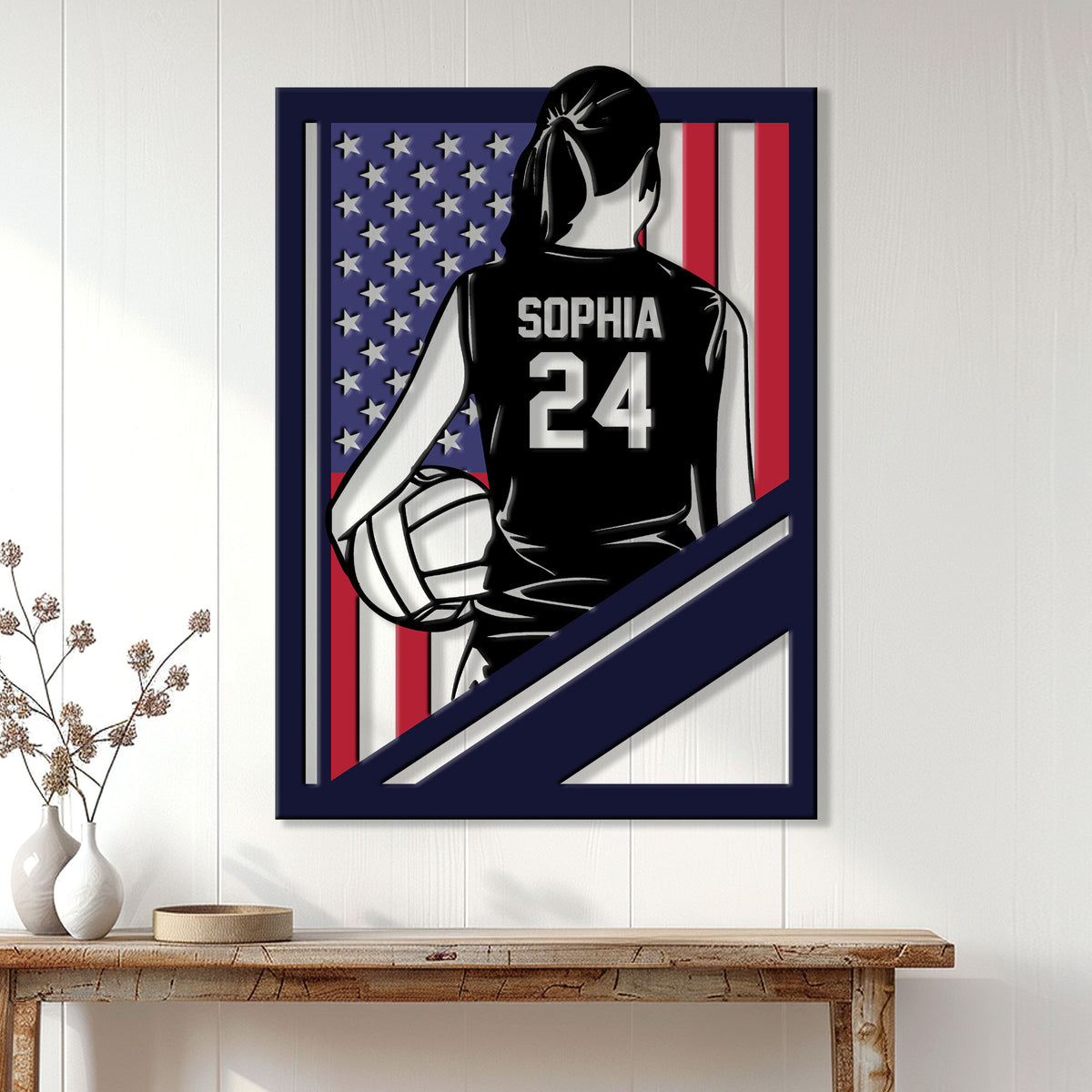 Volleyball wall decor displayed on a light paneled wall, featuring a female player and patriotic flag artwork