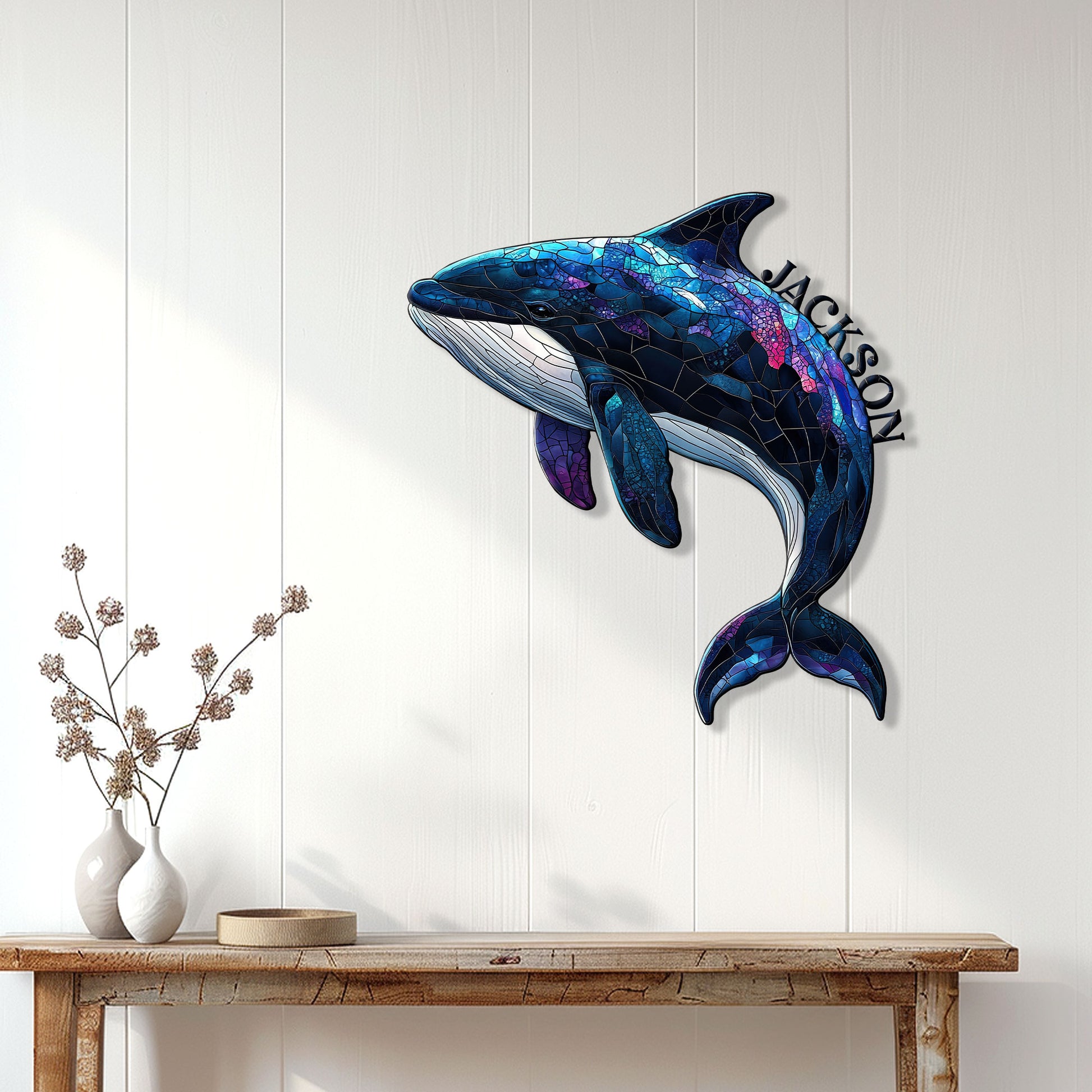 Blue and purple orca wall sign displayed on a white paneled wall above a wooden console table