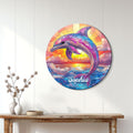 Round dolphin wall sign displayed on a light wood-paneled wall above a console table