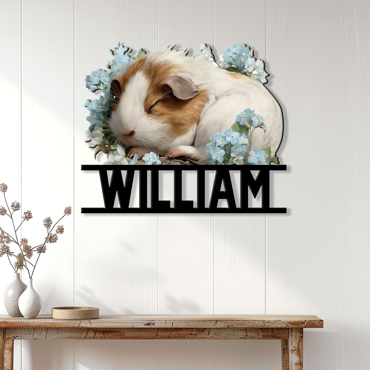 Floral guinea pig wall sign displayed on a light paneled wall above a rustic console table