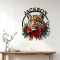 Leopard Christmas wall decor displayed on a white paneled wall above a wood console table