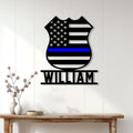 Thin blue line police badge metal sign displayed as wall decor in a bright home entryway