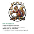 Squirrel cut metal sign featuring colorful stained glass artwork with an acorn and woodland branch