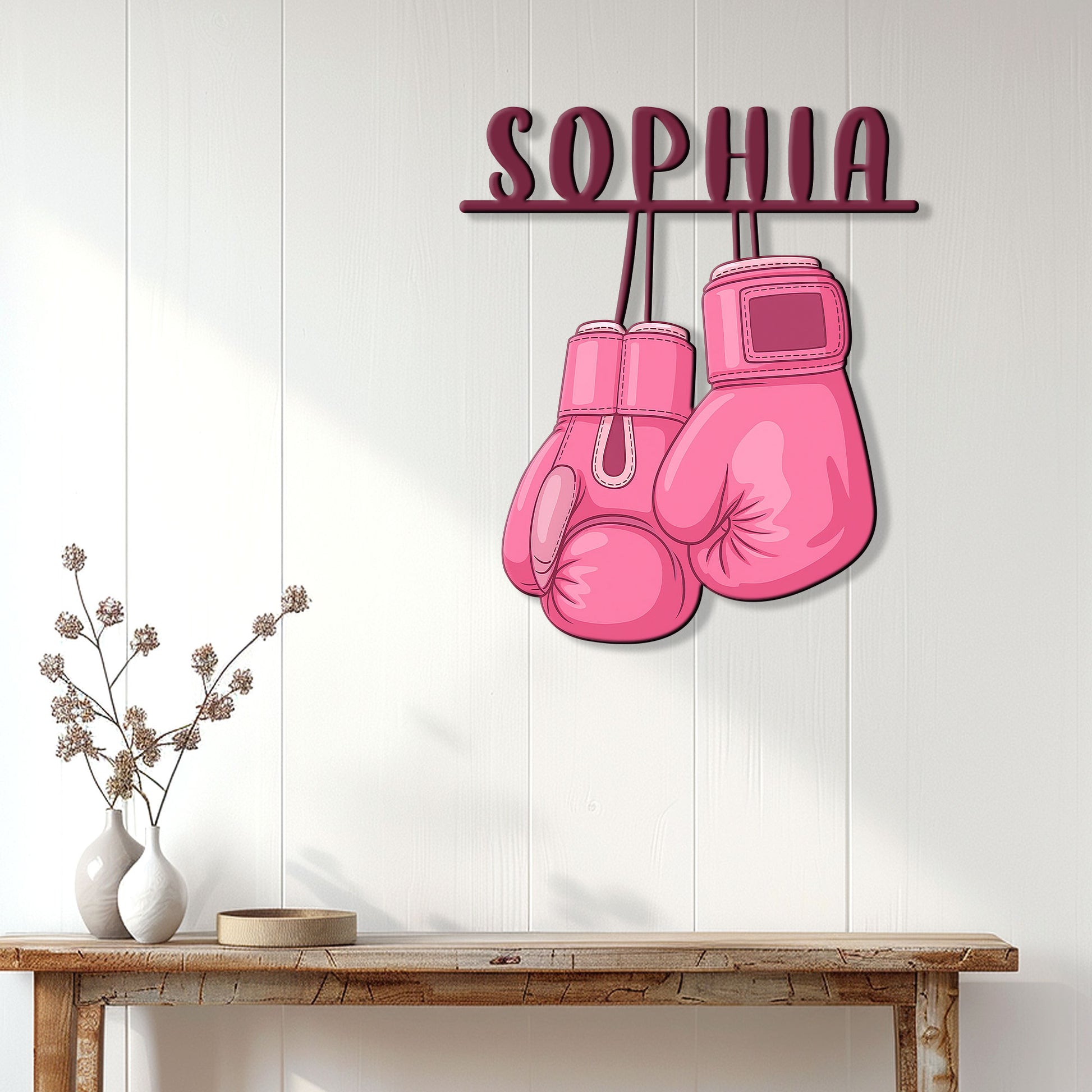 Pink boxing glove breast cancer awareness sign displayed on a light wood-paneled wall