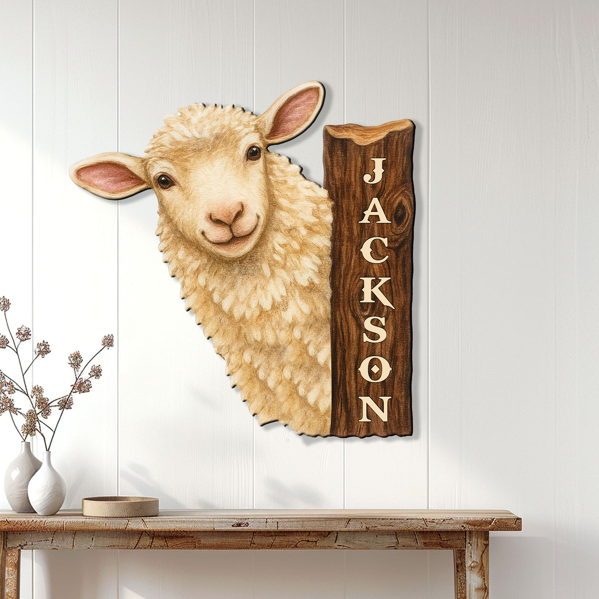 Rustic sheep wall sign displayed on a white paneled wall above a farmhouse console table