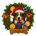Australian Shepherd metal sign featuring a Santa hat, wrapped gifts, holly, pinecones, and a festive bone-shaped accent