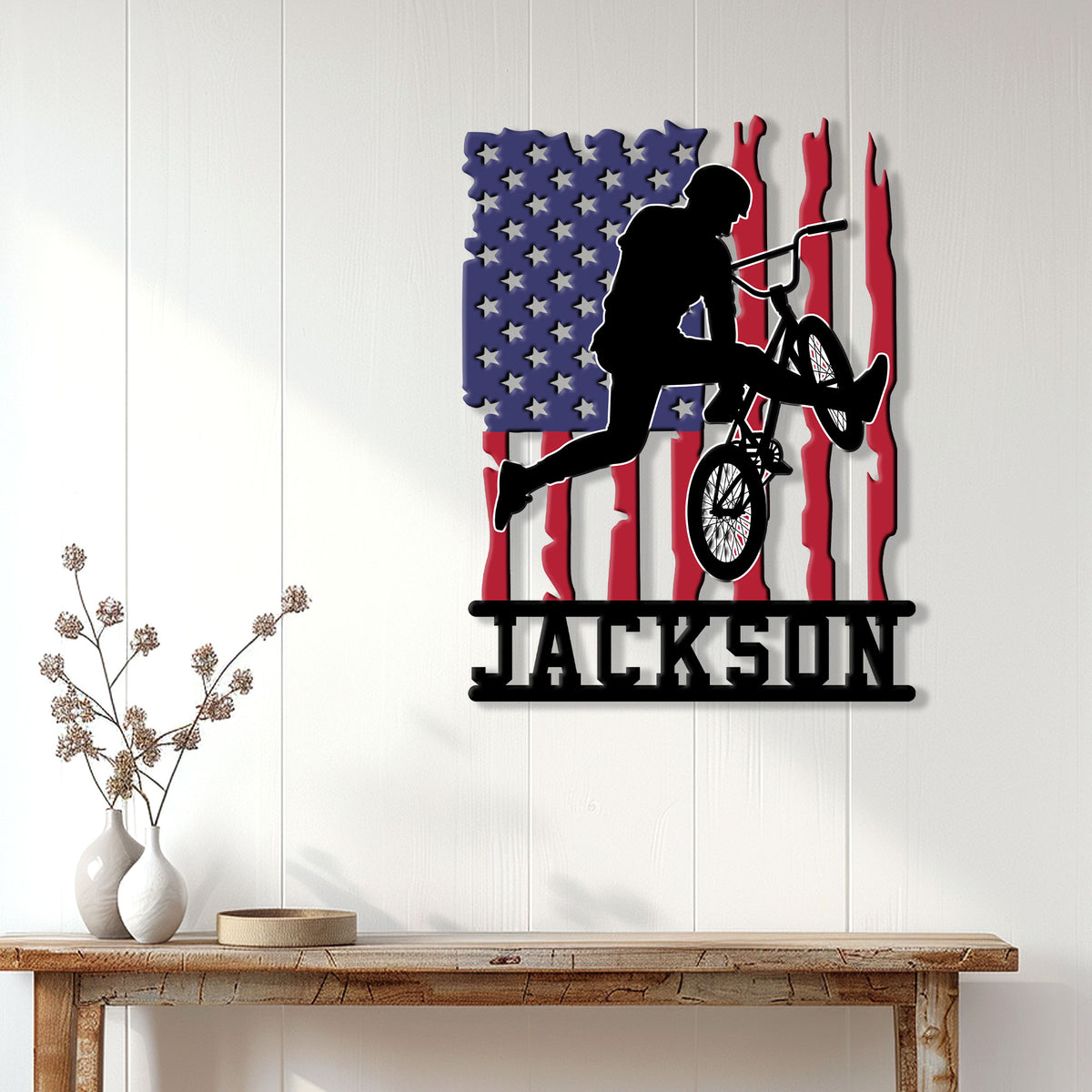 Patriotic BMX rider metal wall sign displayed on a bright paneled wall above a console table