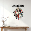 Native American feather wall sign displayed on a light wood-paneled wall above a console table