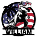 Patriotic T-Rex metal sign featuring sunglasses, an American flag backdrop, and bold dinosaur artwork